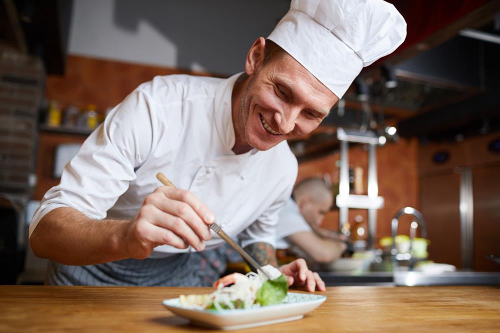 A chef plating an Asian seafood dish