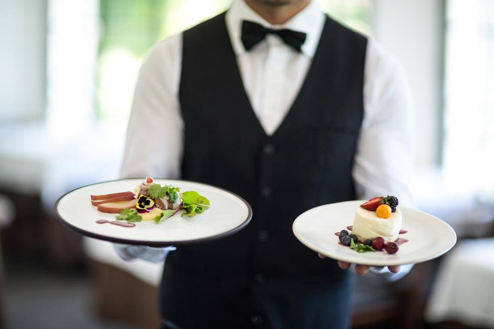 Waiter holding dishes in an elegant restaurant