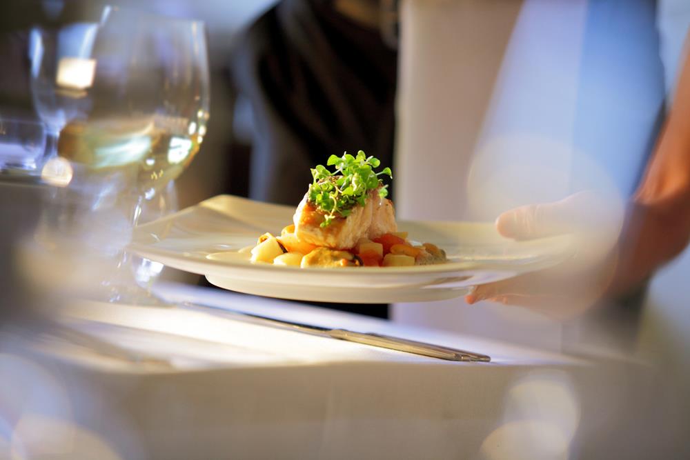 Waiter serving a meal at a table
