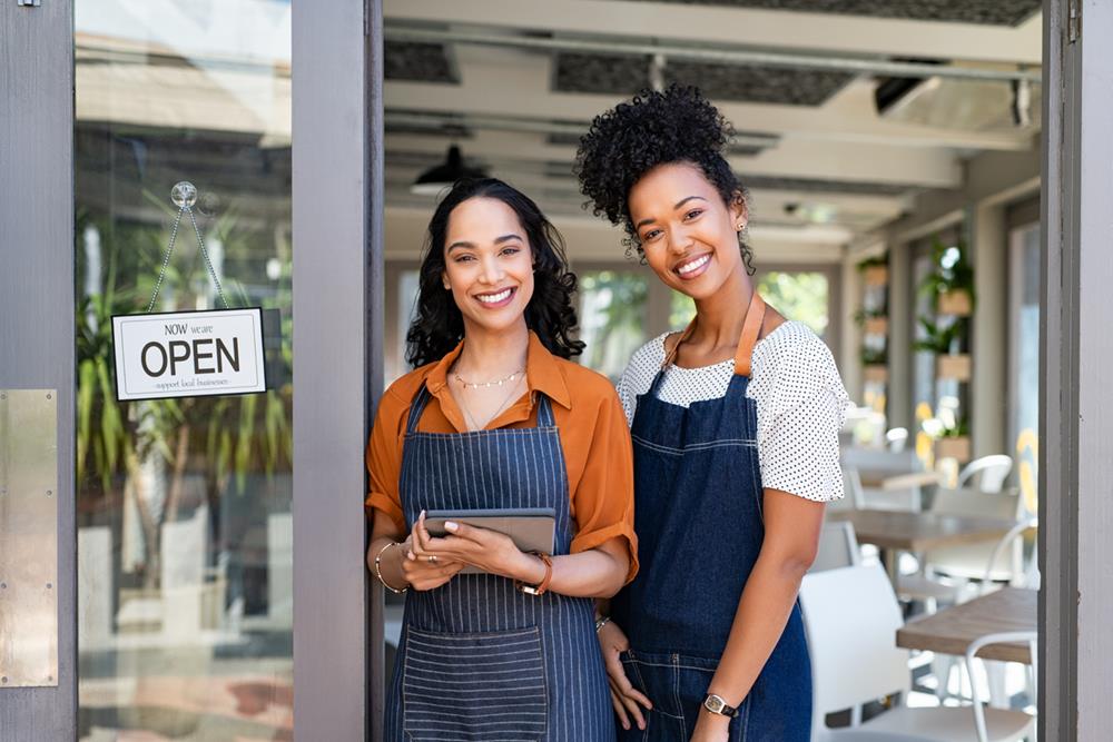 Two women standing at a café entrance