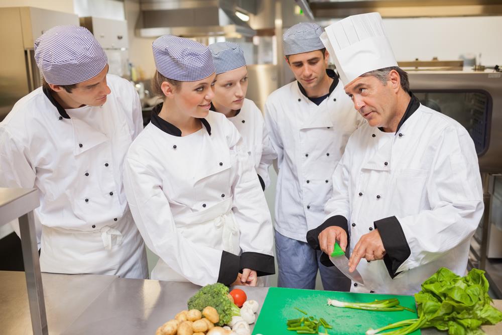 A chef instructing his staff in the kitchen