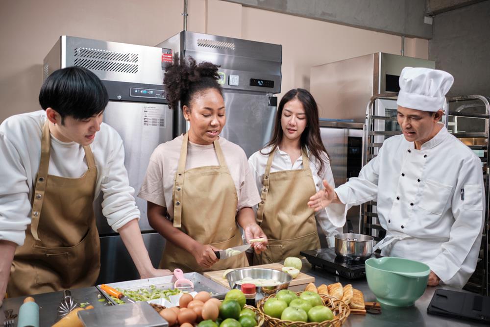 A chef teaching young staff