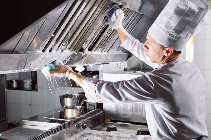 a kitchen worker sanitizing the kitchen