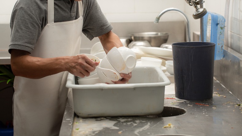 a man sorting the dishes before washing