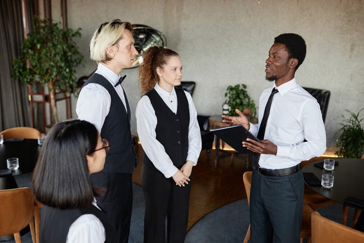 a restaurant service manager talking to servers
