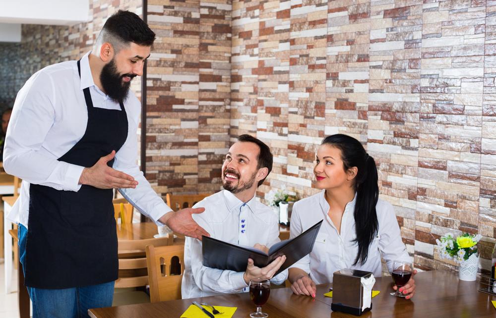Positive waitress taking table order