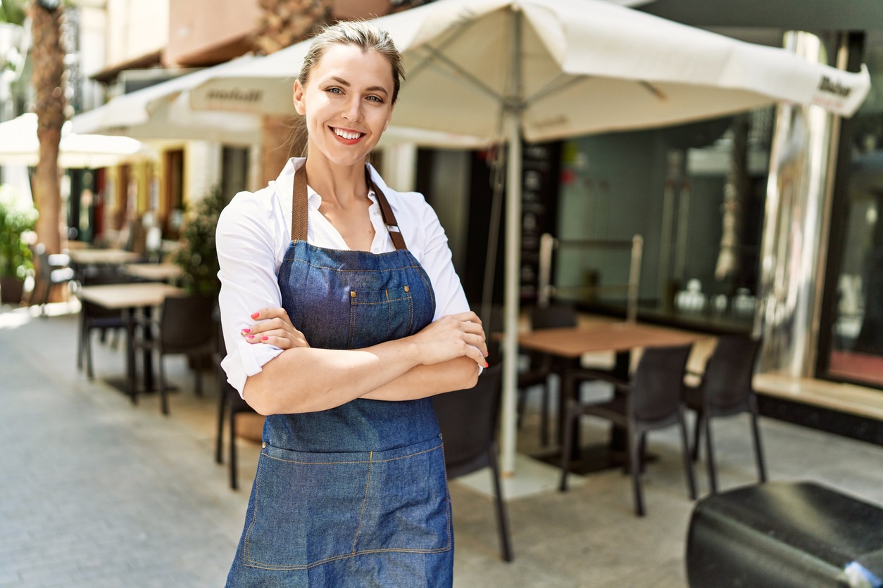 a waitress standing outdoors at a restaurant