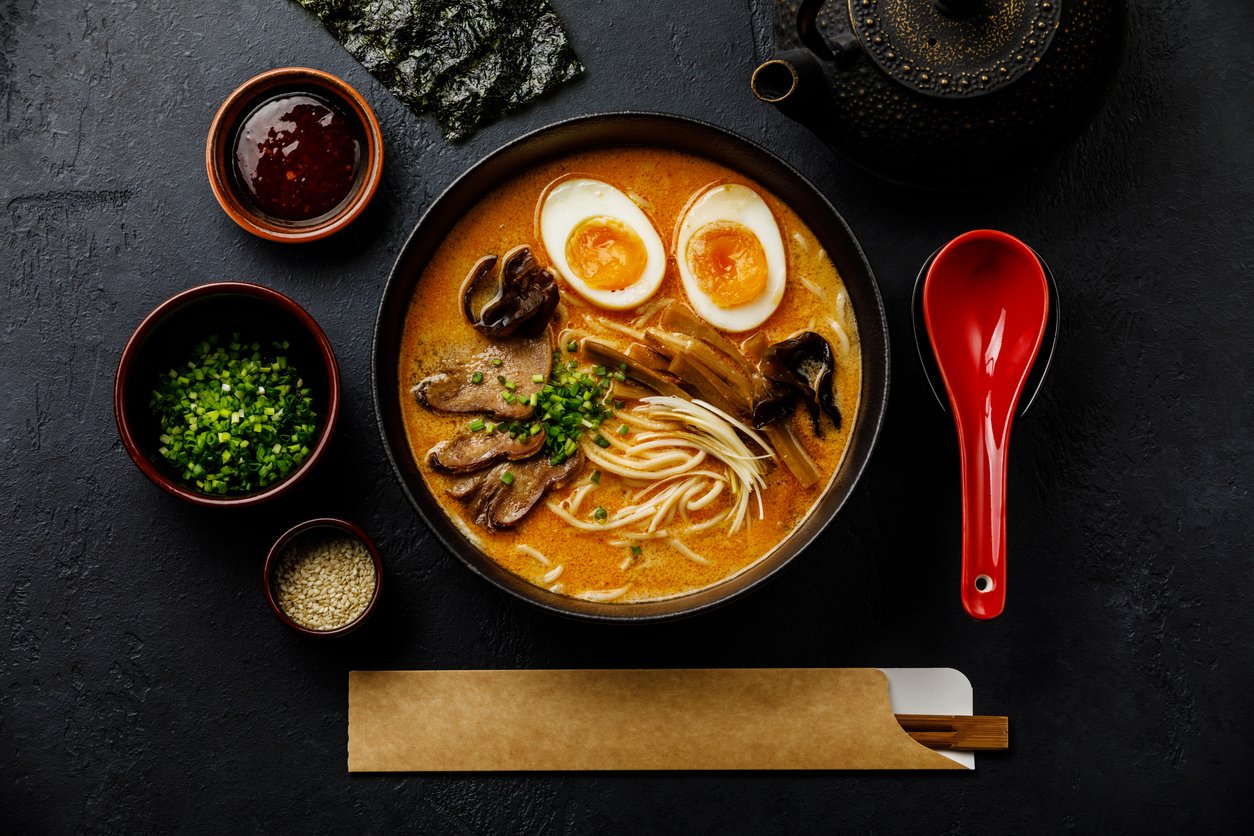 Ramen Asian noodle in broth with Beef tongue meat, mushroom and Ajitama pickled egg in bowl on dark background