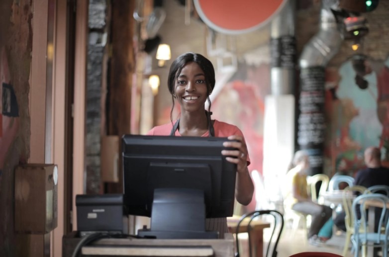 a woman at the counter table with touch screen for orders