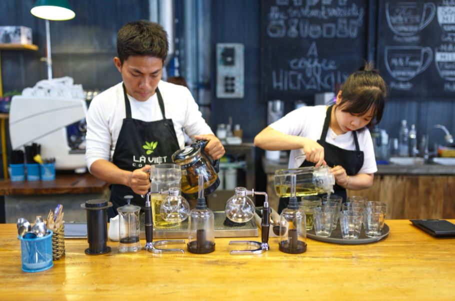 two servers working together as a team while pouring drinks from pitchers